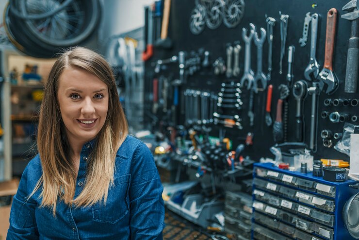 Retrato, de, jovem, femininas, mecânico, em, loja bicicleta