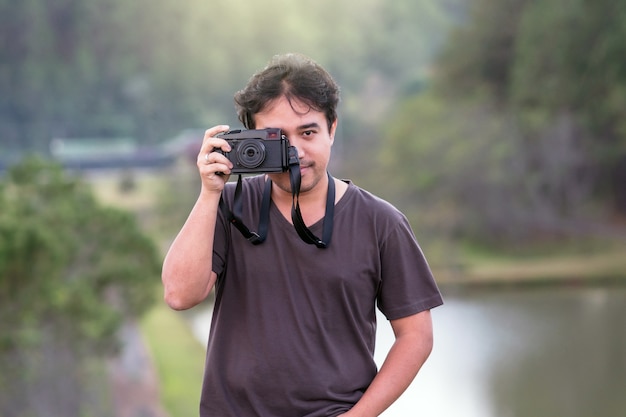 Retrato, de, jovem, fotógrafo, sobre, a, floresta, com, lago, fundo