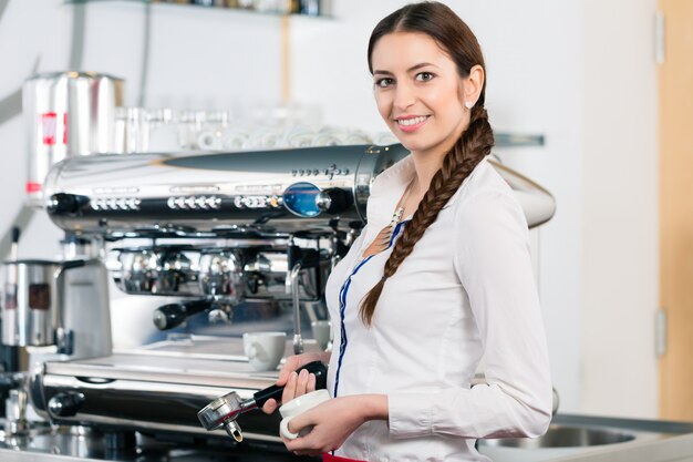 Retrato, de, jovem, garçonete, sorrindo, perto, a, máquina café