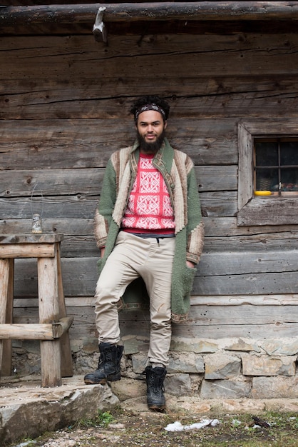 retrato de jovem hipster, homem com barba na frente da velha casa de madeira vintage