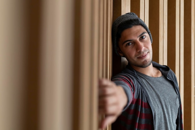 Retrato de jovem hipster latino-americano com atitude relaxada Fundo de madeira