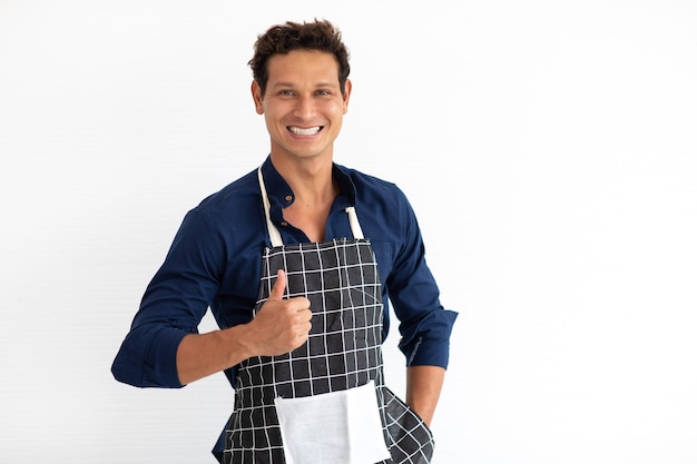 Retrato de jovem hispânico sorridente com avental, olhando para a câmera, isolada no fundo branco