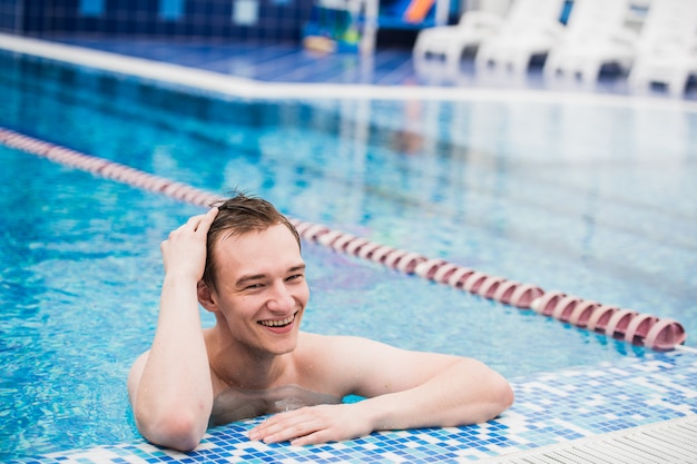 Retrato de jovem homem bonito sexy na piscina
