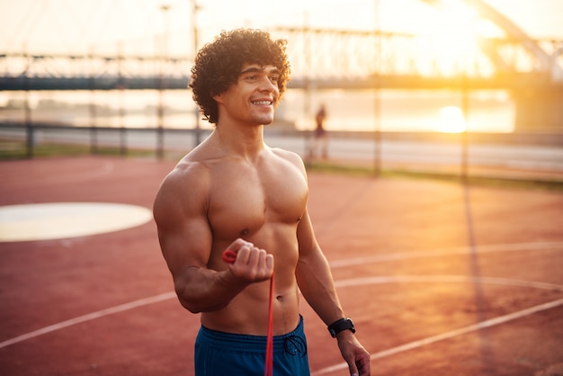 Foto retrato de jovem homem musculoso feliz treinando fora de manhã cedo