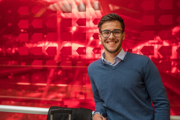 Foto retrato de jovem homem usando óculos sorrindo olhando para o close-up da câmera