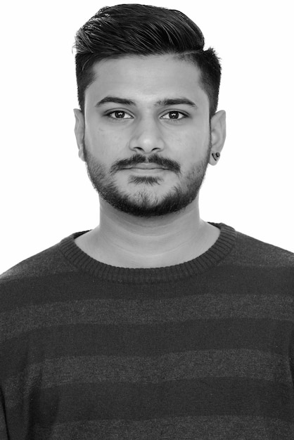 Retrato de jovem indiano barbudo bonito em branco em preto e branco