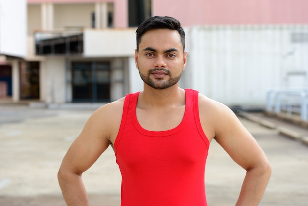 Retrato de jovem indiano barbudo bonito pronto para a academia