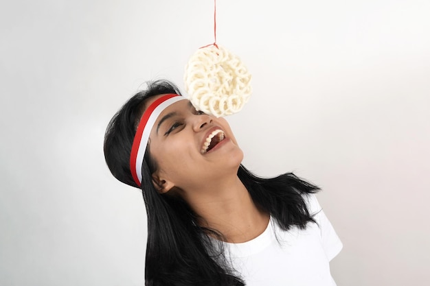 retrato de jovem indonésia comendo bolachas na celebração do dia da independência da Indonésia