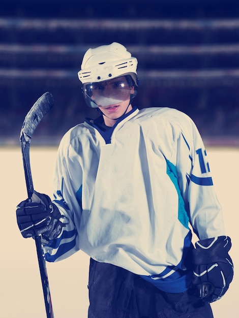 retrato de jovem jogador de hóquei no gelo em treinamento em fundo preto