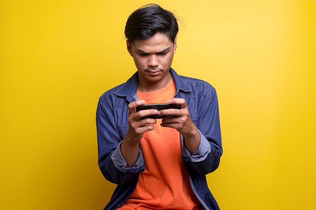 Retrato de jovem jogando jogos no celular com expressão séria