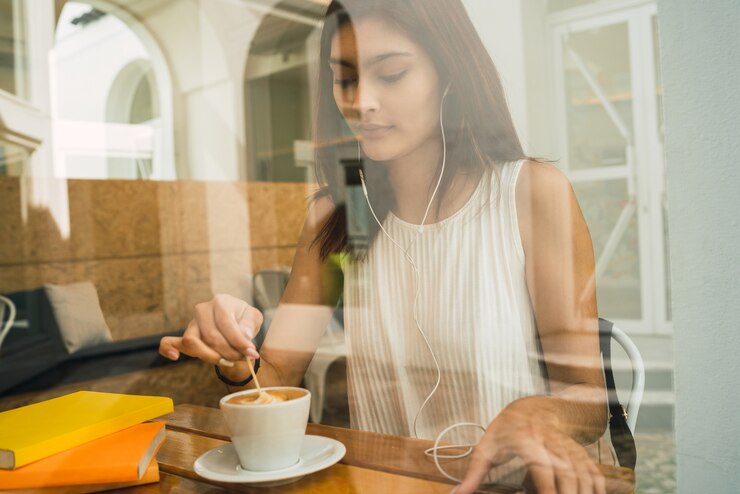 Foto retrato de jovem latina, desfrutando e bebendo uma xícara de café na cafeteria