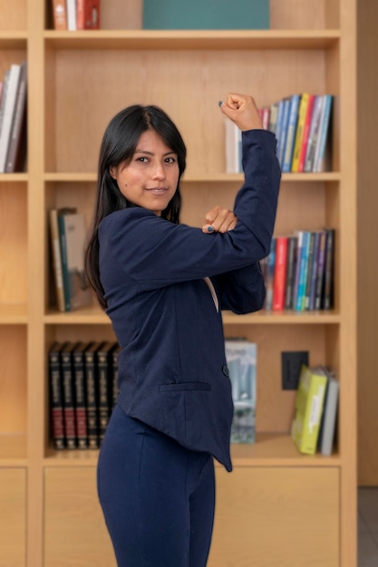 Retrato de jovem latina mostrando sinal de empoderamento feminino com seus braços símbolo do poder feminino