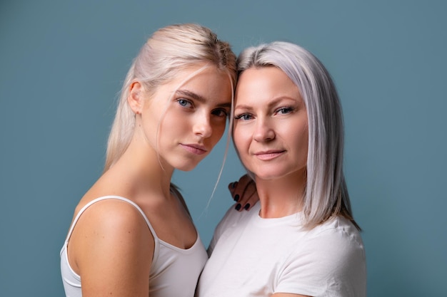 Retrato de jovem mãe e filha no conceito de família de fundo azul