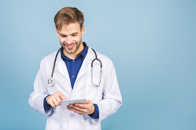 Retrato de jovem médico alegre e sorridente com estetoscópio isolado