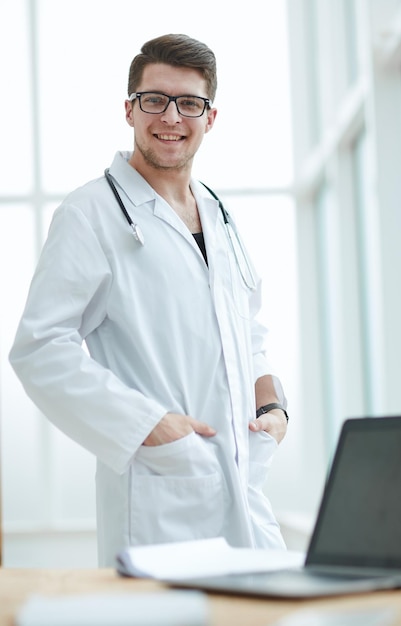 Retrato de jovem médico bonito no consultório médico