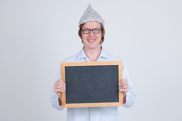 Retrato de jovem médico bonito usando chapéu de papel alumínio como conceito de teoria da conspiração em branco