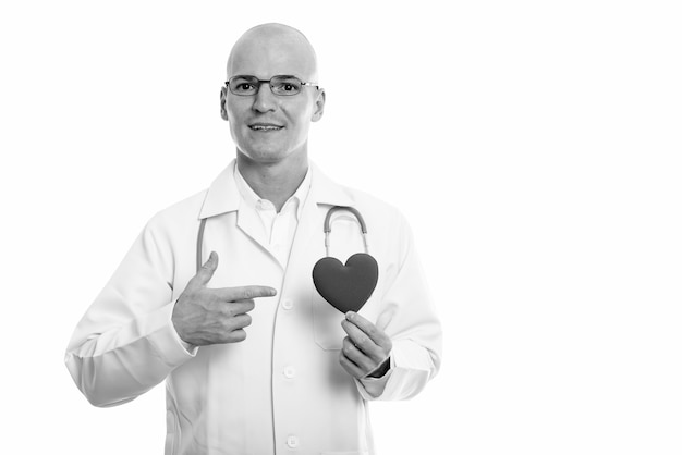 Retrato de jovem médico careca bonito isolado no branco em preto e branco