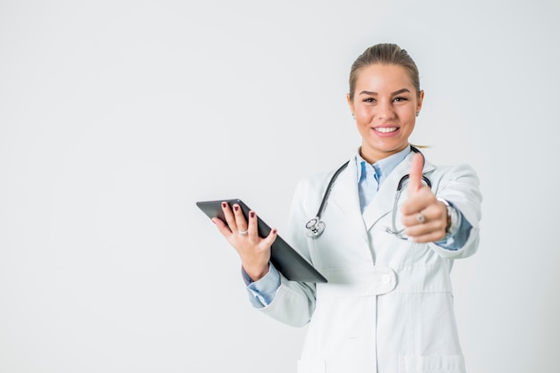 Retrato, de, jovem, médico feminino, com, tabuleta, mostrando, polegar cima