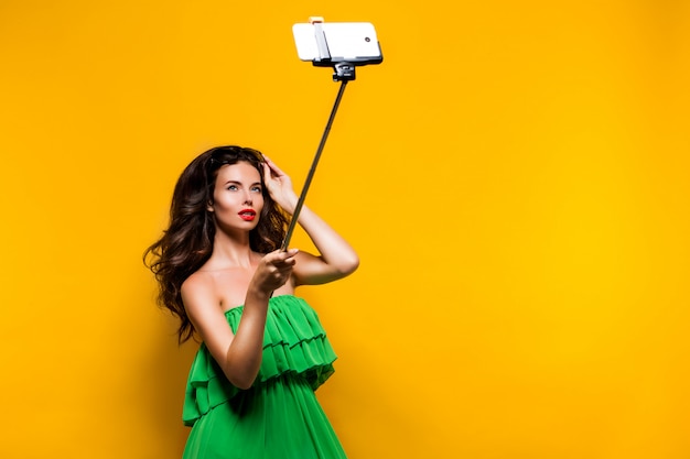 Retrato de jovem modelo de vestido verde e óculos de sol posando whi