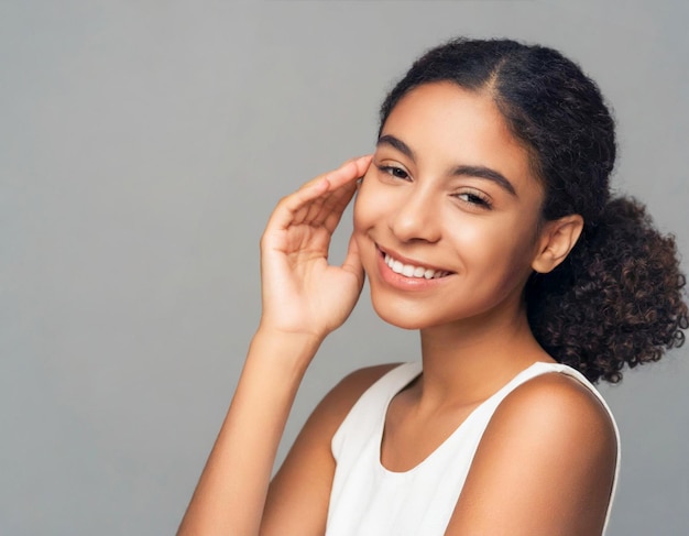 Retrato de jovem mulher afro-americana com pele facial limpa e saudável em fundo cinza