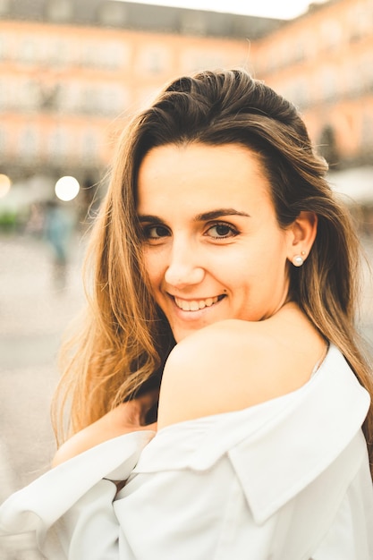 Retrato de jovem mulher caucasiana com uma blusa branca e uma saia preta na Plaza Mayor de Madrid, Espanha.