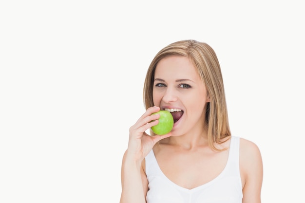 Retrato de jovem mulher comendo maçã verde