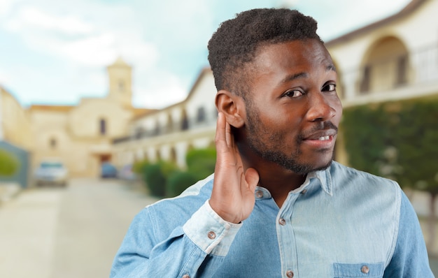 Retrato de jovem negro legal tentando ouvir