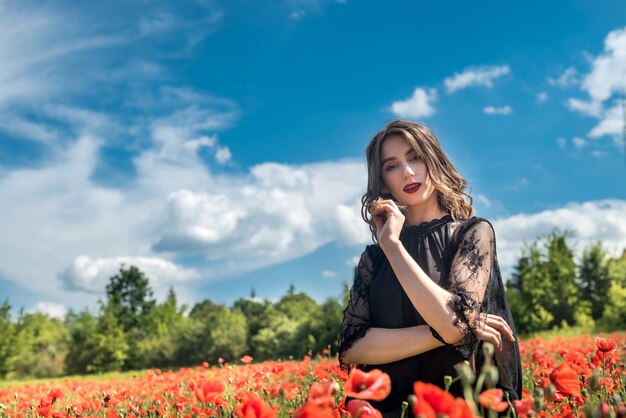 Retrato de jovem no campo de papoilas vermelhas. aproveite o tempo na natureza