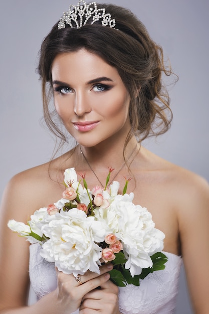 Foto retrato de jovem noiva linda com buquê de flores