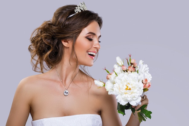 Foto retrato de jovem noiva linda com buquê de flores