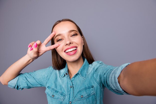 Retrato de jovem posando contra uma parede cinza