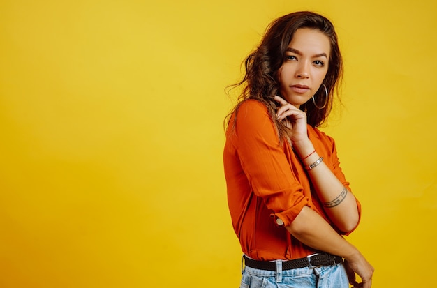 Retrato de jovem posando em amarelo.