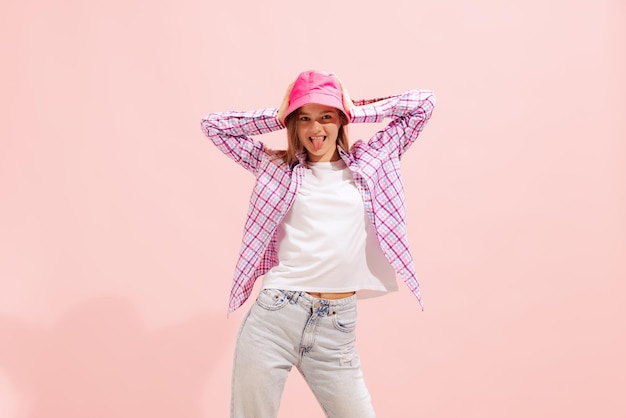 Retrato de jovem posando em roupas casuais com panamá brilhante isolado sobre estúdio rosa