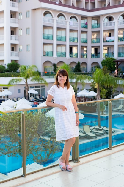 Retrato de jovem posando no terraço de verão do hotel
