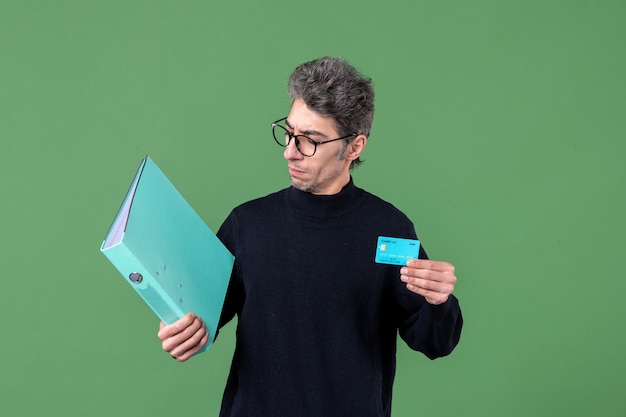 Retrato de jovem segurando documento e cartão de crédito sobre fundo verde natureza banco professores dinheiro masculino