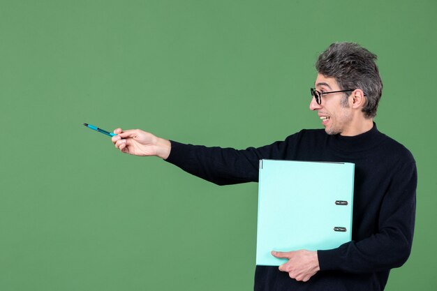 retrato de jovem segurando um documento verde sobre fundo verde, professor de aula de negócios