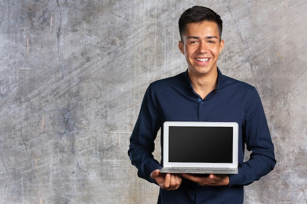 Retrato de jovem sorridente com laptop