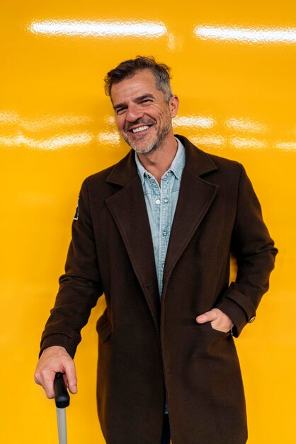 Retrato de jovem sorridente contra a parede amarela