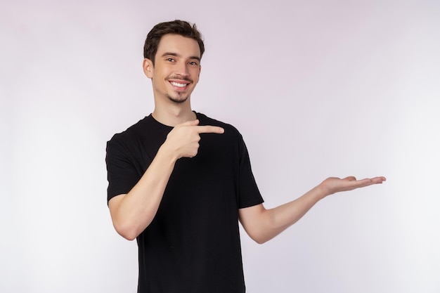 Retrato de jovem sorridente feliz apresentando e mostrando seu texto ou produto isolado no fundo branco