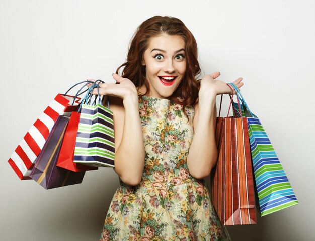 Retrato de jovem sorridente feliz com sacos de compras