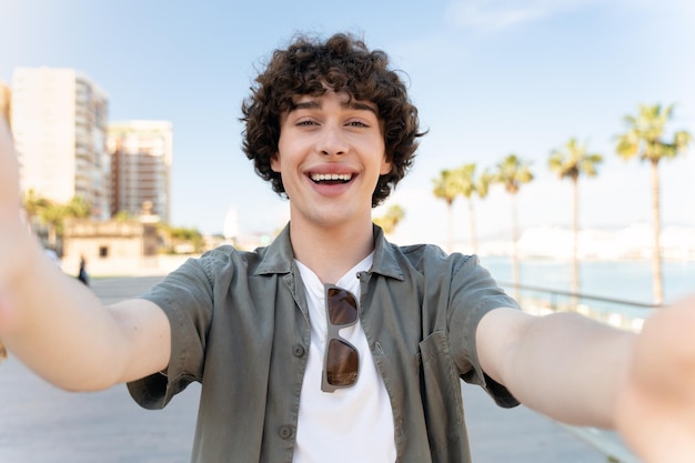 Retrato de jovem sorridente tirando foto de selfie