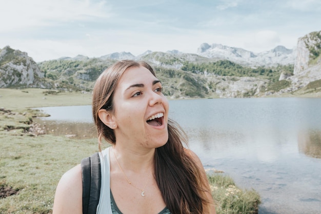 Retrato de jovem surpreso após chegar ao topo das montanhas após um dia de viagem Idílico