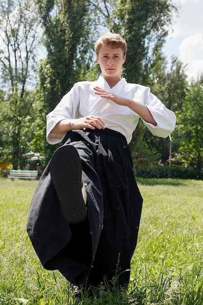 Foto retrato de jovem taekwondo exercitando-se no parque natural