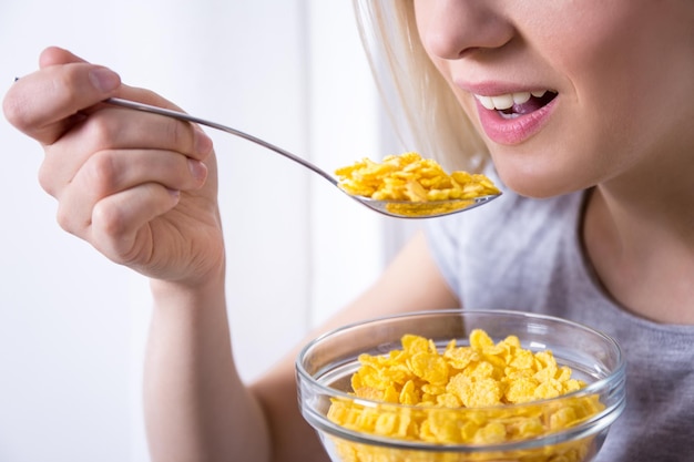 Retrato de jovem tomando café da manhã com flocos de milho