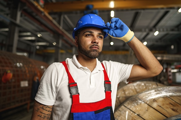 Foto retrato de jovem trabalhador afro-americano cansado na fábrica de produção de cabos