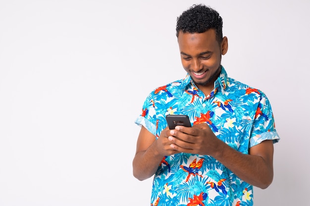 Retrato de jovem turista africano bonito contra uma parede branca