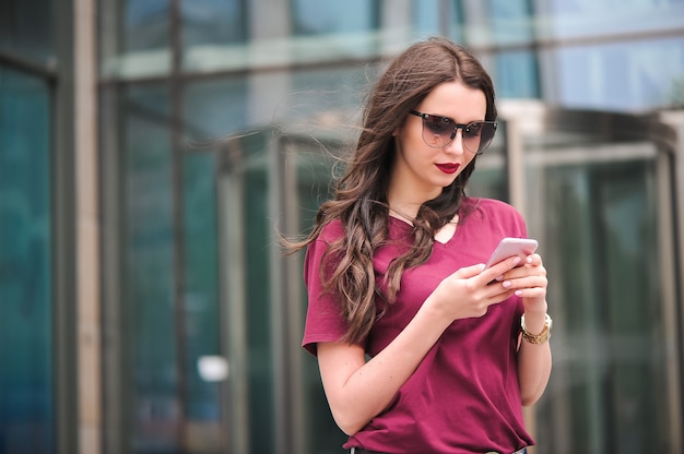 Retrato de jovem turista na cidade, usando telefone celular