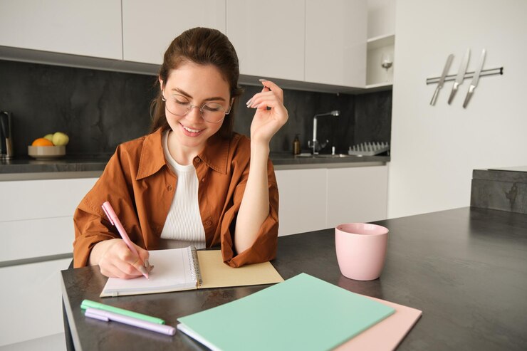 Foto retrato de jovem tutora sorridente preparando anotações para a lição em casa escrevendo em caderno e