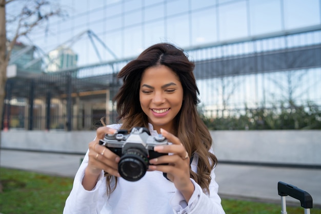 Retrato de jovem usando a câmera enquanto tirava fotos na cidade. Novo conceito de estilo de vida normal.