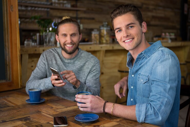 Foto retrato de jovens sorridentes sentados à mesa de um café